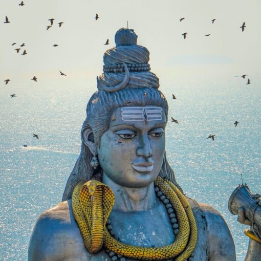 a statue of a hindu god with birds in the background